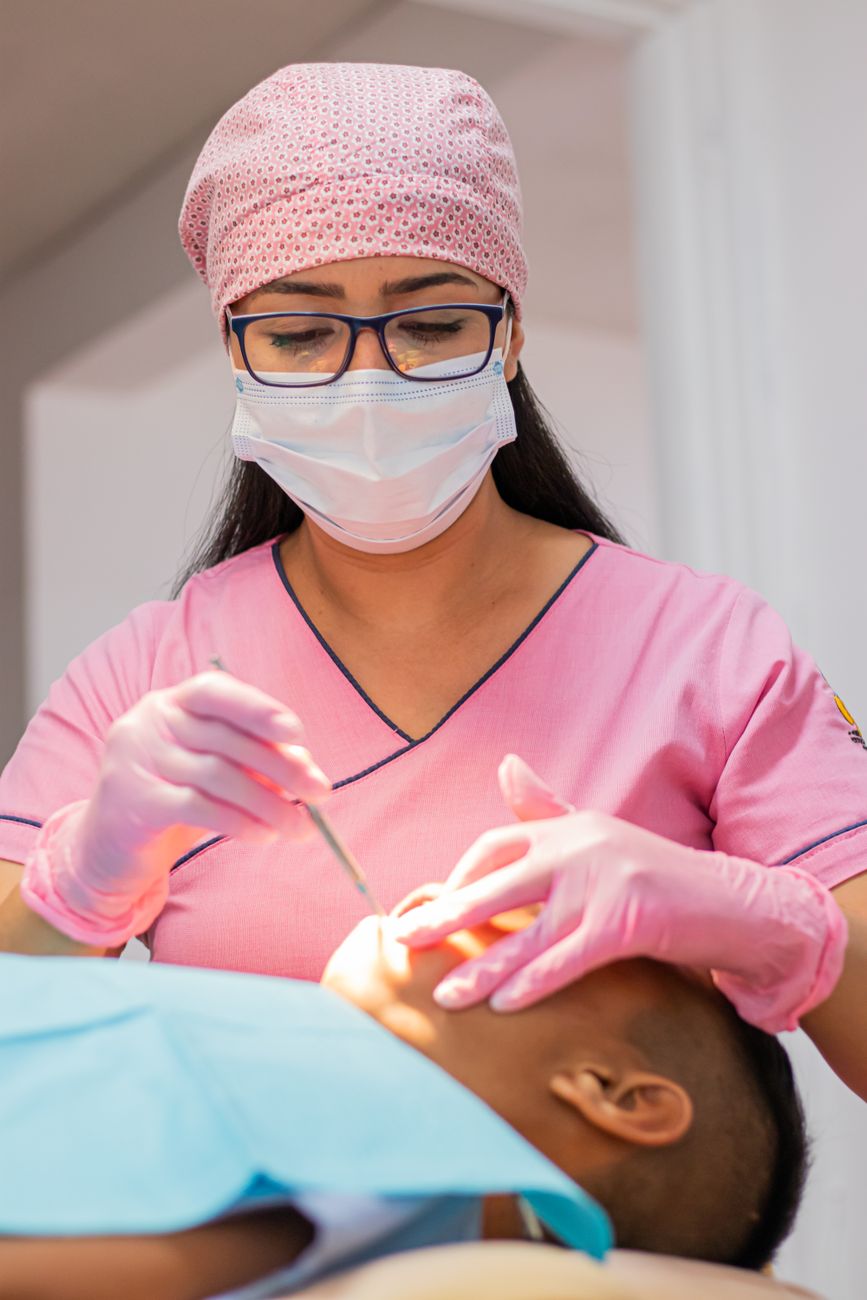 dental hygienist cleaning patient's teeth